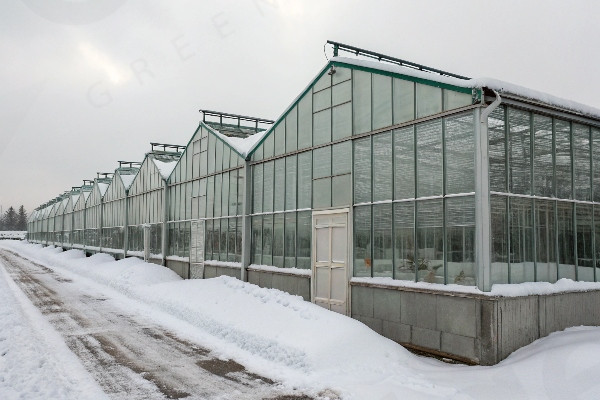 Deep winter greenhouse with snow coverage showing insulation systems