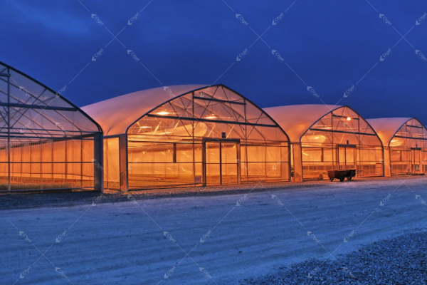 A sturdy greenhouse covered in snow in a mountainous region